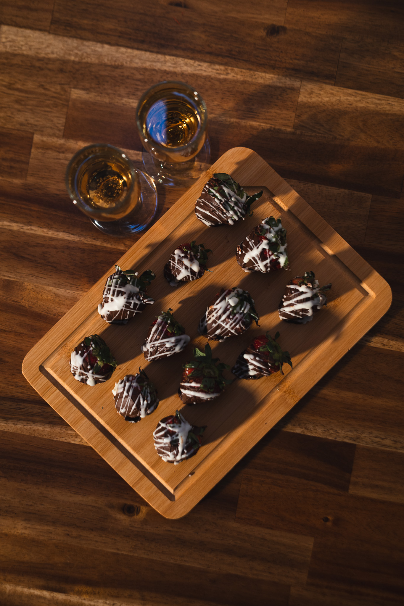 Chocolate-covered strawberries and sparkling wine on a wooden board