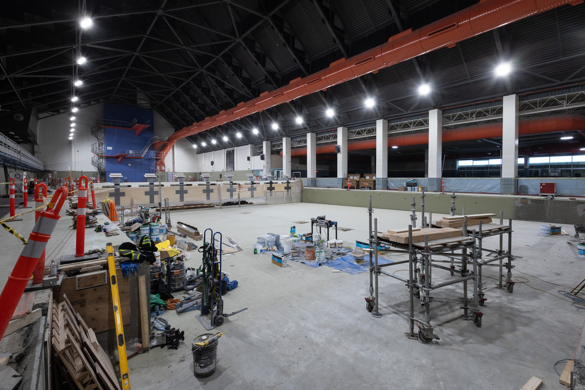 Interior of a large arena facility under construction with scaffolding