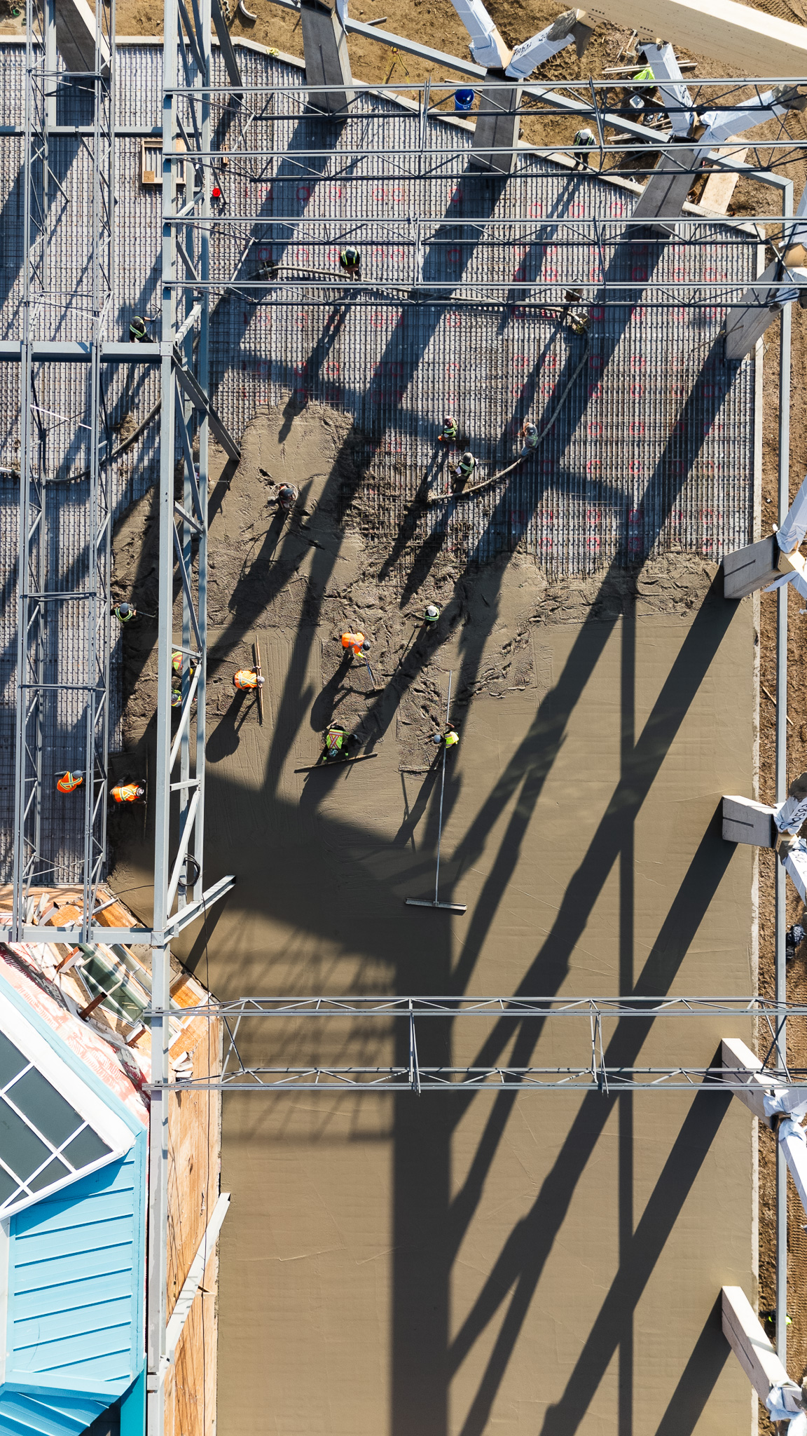 Aerial view of construction site with steel framework and workers pouring concrete