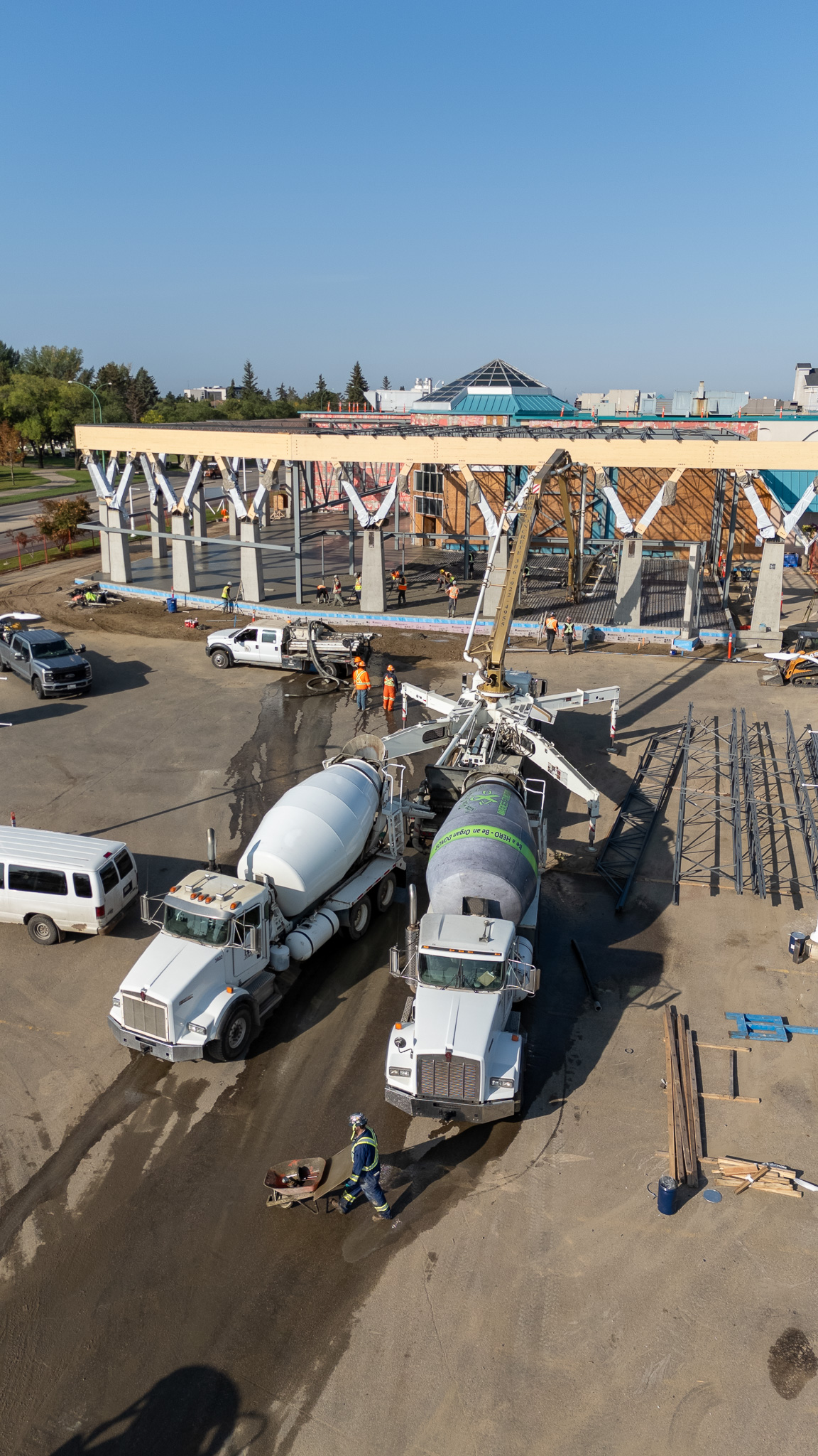 Aerial shot of cement mixer trucks at active construction site